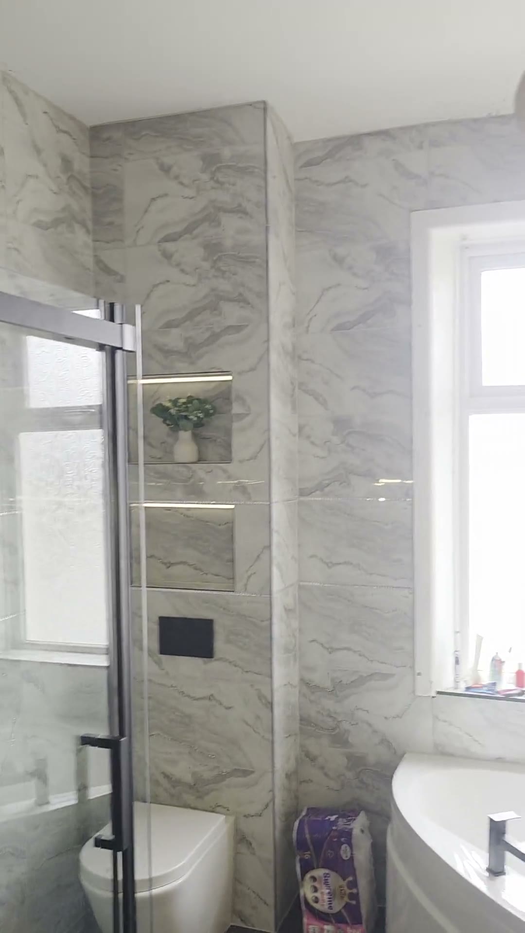 Wall-hung toilet with black flush plate and dual LED niches