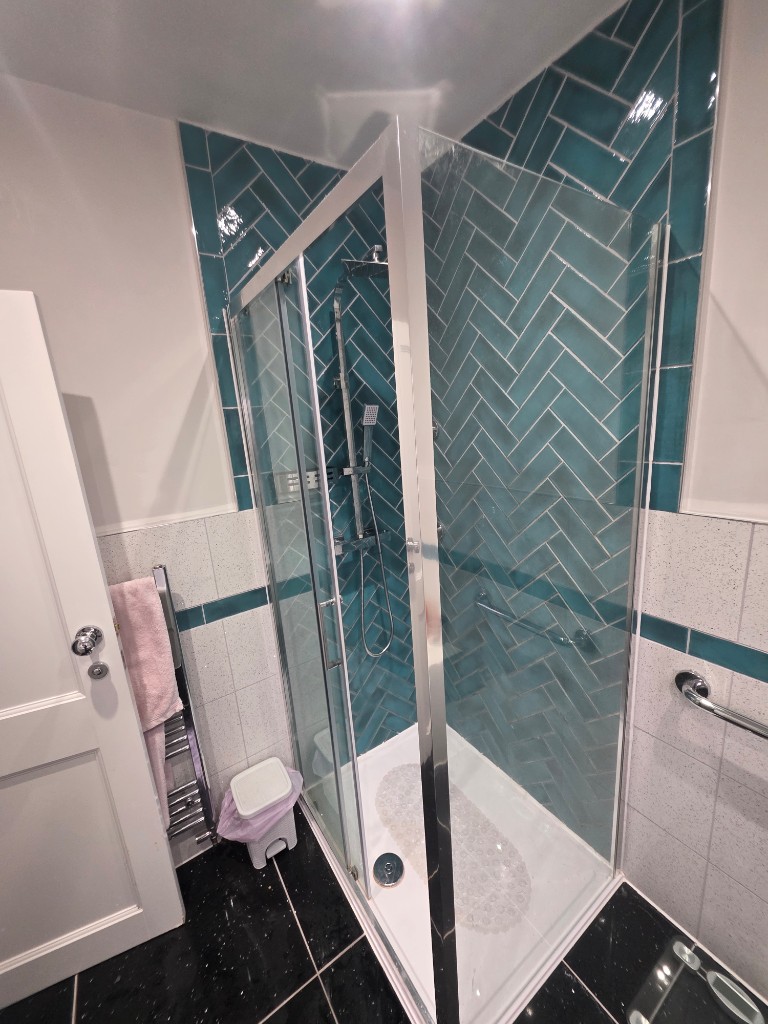 Corner shower enclosure with teal feature walls