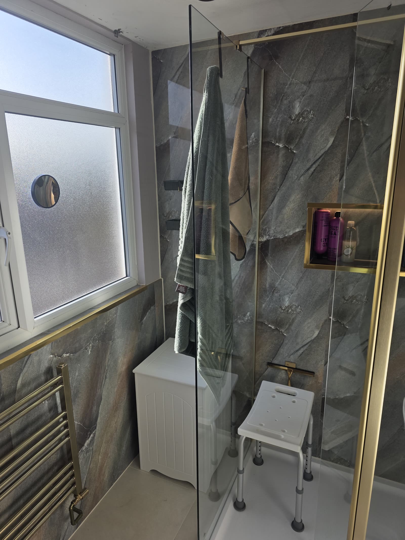 Bathroom detail — gold fittings and stone-effect PVC panels