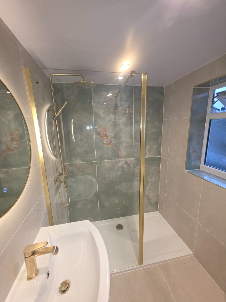 Walk-in shower with green marble feature wall and brushed gold rainfall shower