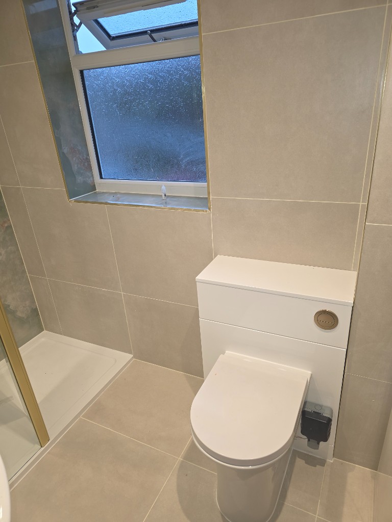 Back-to-wall toilet with concealed cistern and gold flush plate